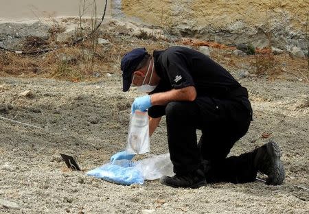 A South Yorkshire police officer investigates the ground before commencing excavating a site for Ben Needham, a 21 month old British toddler who went missing in 1991, on the island of Kos, Greece, September 26, 2016. REUTERS/Vassilis Triandafyllou