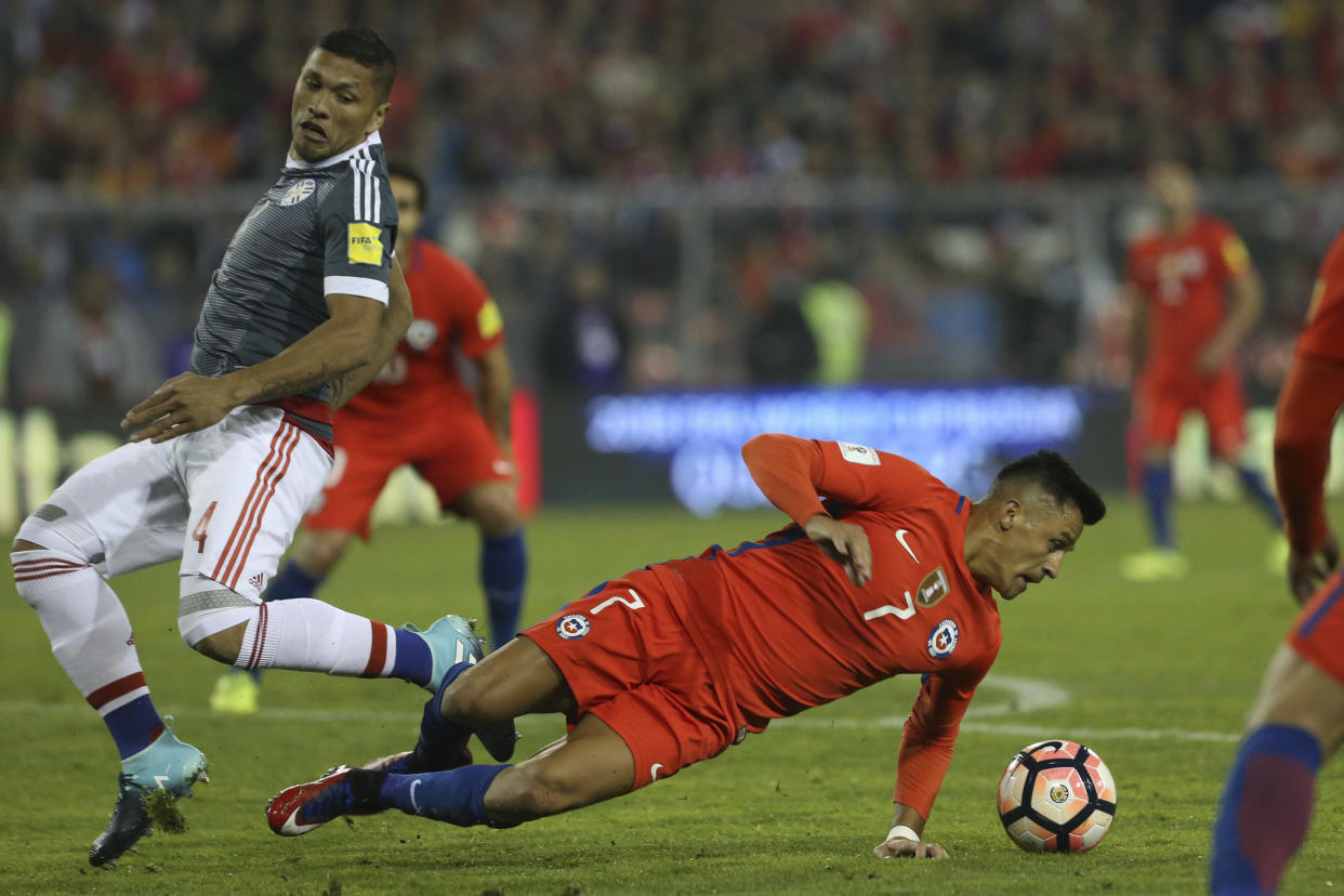 Chile’s Alexis Sanchez, right, falls as he fights for the ball with Paraguay’s Richard Ortiz, left, during a 2018 World Cup qualifying soccer match in Santiago, Chile, Thursday, Aug. 31, 2017. (AP Photo/Esteban Felix)