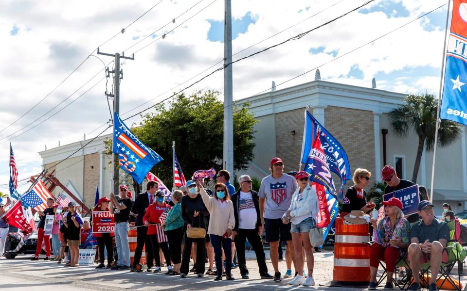 Supporters of Donald Trump gather along the route of his motorcade on Southern Boulevard as he arrives in Florida - AFP