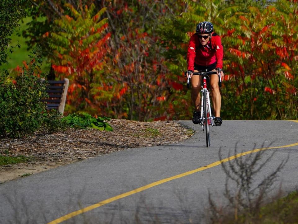 A cyclist makes their way along the banks of the Ottawa River in Ottawa on Wednesday, Oct. 20, 2021. (Sean Kilpatrick/The Canadian Press - image credit)