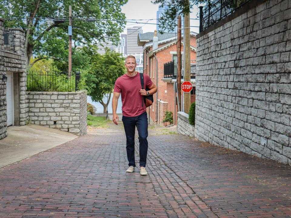 Brennan Schlagbaum caminando por un camino de ladrillos en una zona urbana mientras llevaba una mochila.