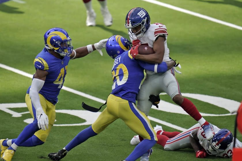 New York Giants wide receiver Golden Tate, right, is tackled by Los Angeles Rams cornerback Jalen Ramsey.