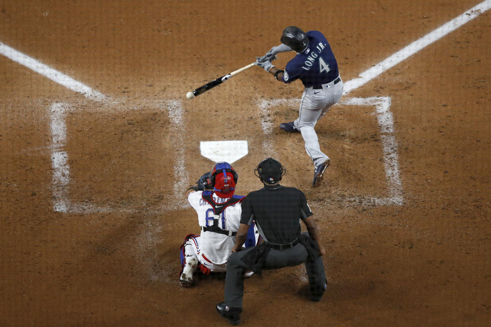 Seattle Mariners' Shed Long Jr. (4) grounds out to third as Texas Rangers catcher Robinson Chirinos (61) and umpire Edwin Moscoso look on in the second inning of a baseball game in Arlington, Texas, Monday, Aug. 10, 2020. (AP Photo/Tony Gutierrez)