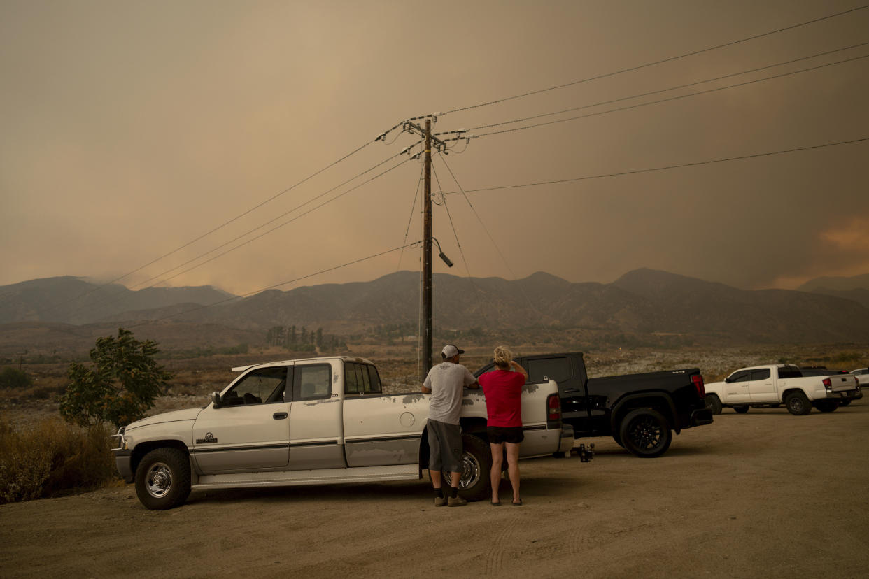 People watch as a fire advances.