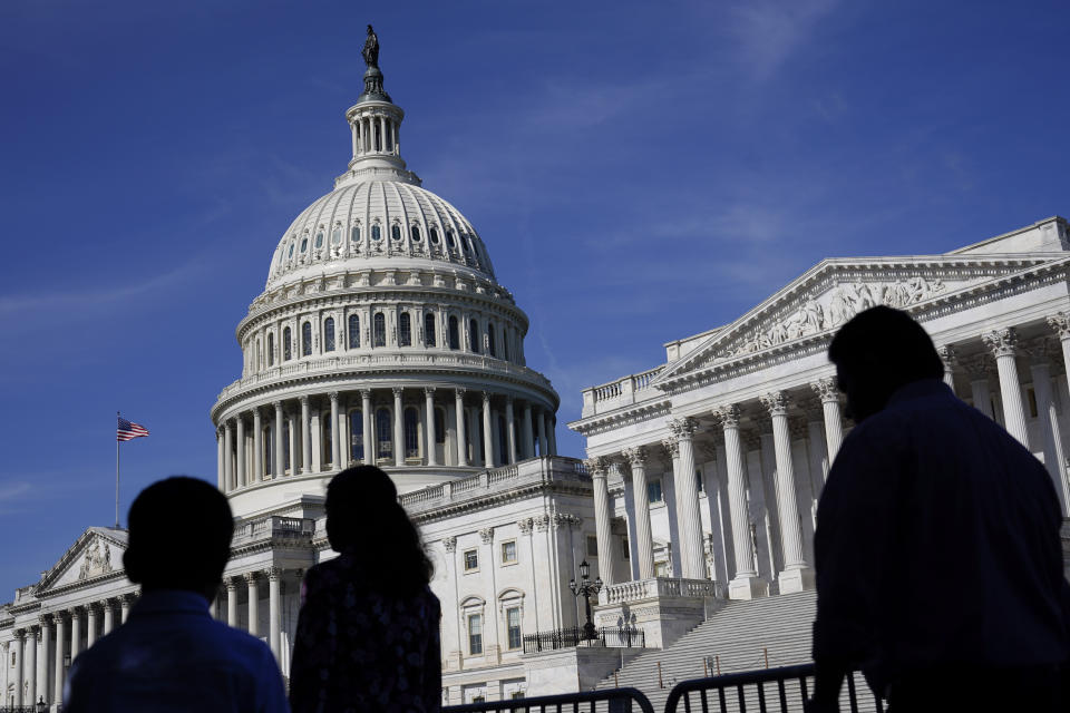 FILE - People walk outside the U.S Capitol building in Washington, June 9, 2022. A Democratic economic package focused on climate and health care faces hurdles but seems headed toward party-line passage by Congress next month. Approval would let President Joe Biden and his party claim a triumph on top priorities just as November’s elections approach. . (AP Photo/Patrick Semansky, File)