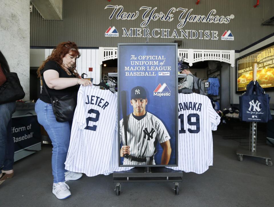 Elaine Rosenkranz, from Galloway, New Jersey, looks at a Derek Jeter jersey after watching a New York Yankees spring training baseball practice Tuesday, Feb. 18, 2014, in Tampa, Fla. (AP Photo/Charlie Neibergall)