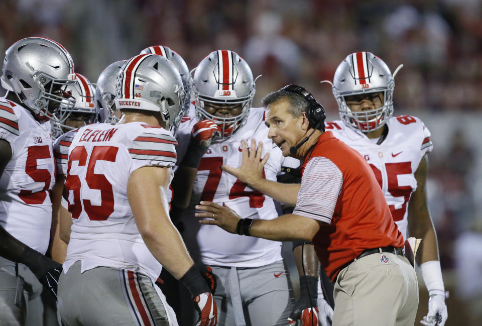 FILE - In this Sept. 17, 2016, file photo, Ohio State head coach Urban Meyer talks with his players in the fourth quarter of an NCAA college football game against Oklahoma, in Norman, Okla. Meyer’s current suspension and previous paid leave have restricted him from talking football with his staff and athletes during August with one exception _ a team meeting the day after the suspension was announced. Emails from the senior vice president for human resources show Meyer and athletic director Gene Smith were allowed to meet with the players and coaches last Thursday, Aug. 23, 2018. (AP Photo/Sue Ogrocki, File)