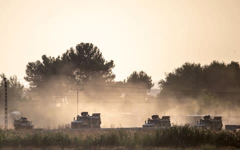 Turkish army vehicles drive towards the Syrian border near Akcakale  - Credit: BULENT KILIC/AFP