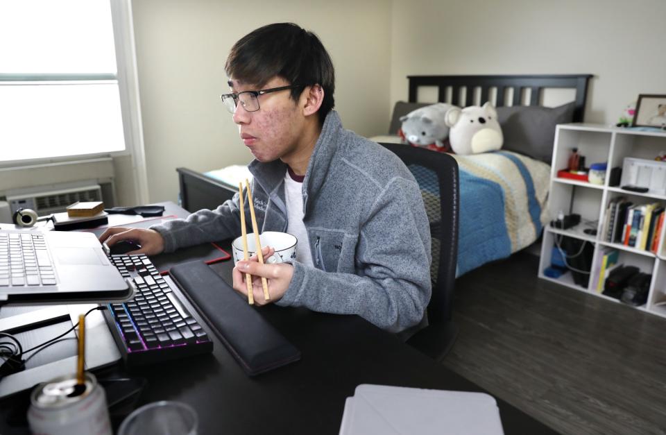 Raven Ferrer does schoolwork on a laptop while dining at home in Monterey Park.