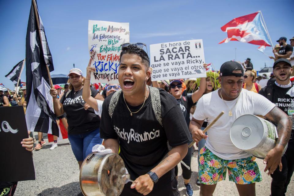 Demonstrators bang on pots and buckets as they march on Las Americas highway demanding the resignation of governor Ricardo Rossello, in San Juan, Puerto Rico, Monday, July 22, 2019. Protesters are demanding Rossello step down for his involvement in a private chat in which he used profanities to describe an ex-New York City councilwoman and a federal control board overseeing the island's finance. (AP Photo/Dennis M. Rivera Pichardo)