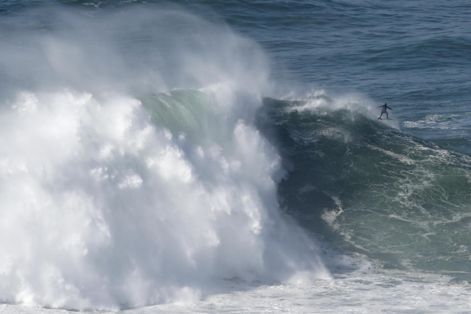 A surfer exits a wave during a tow surfing session at Praia do Norte or North Beach in Nazare, Portugal, Thursday, Oct. 29, 2020. A big swell generated earlier in the week by Hurricane Epsilon in the North Atlantic, reached the Portuguese west coast drawing big wave surfers to Nazare. (AP Photo/Pedro Rocha)