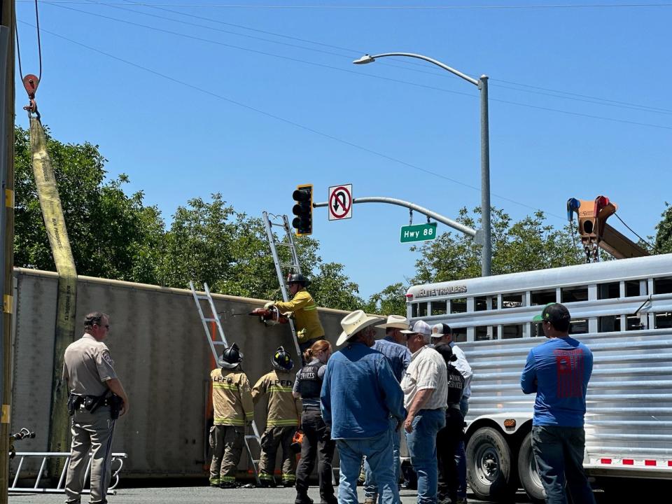 First responders cut open the trailer of a cattle truck that overturned on a car near Waterloo Road and Alpine Road in Stockton on May 16, 2023.