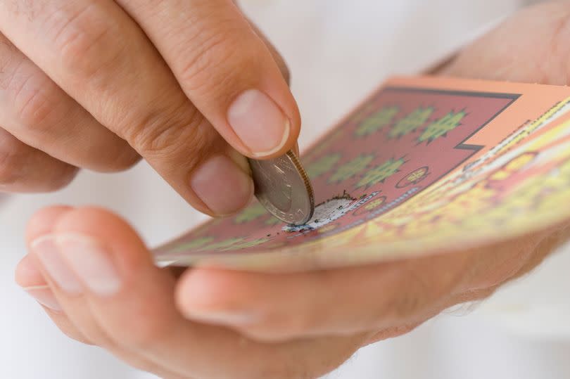 A National Lottery punter plays a scratchcard game (file image)