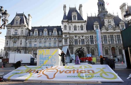 Employees put the final touches during the installation of the exhibition "Paris de L'Avenir", a showcase for tangible climate solutions in the context of the COP21 World Climate Summit, in front of Paris city hall, France, November 26, 2015. REUTERS/Eric Gaillard