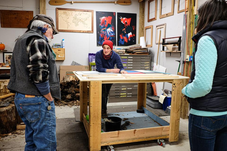 Megan Shannon, center, answers questions from woodworking students Angelo Pecora, left, and Erika Poli during a frame making class at Tiny Bit of Wood School in Holt Sunday, Nov. 21, 2021.