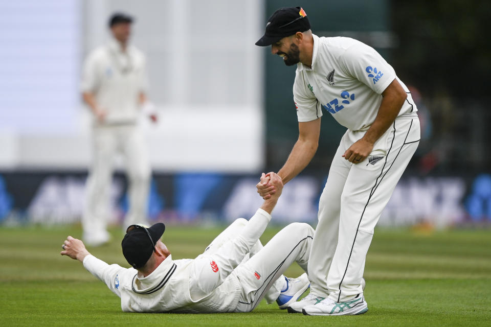 New Zealand's Glenn Phillips is helped back to his feet by teammate Daryl Mitchell on day four of the second cricket test between New Zealand and Australia in Christchurch, New Zealand, Monday, March 11, 2024. (John Davidson/Photosport via AP)