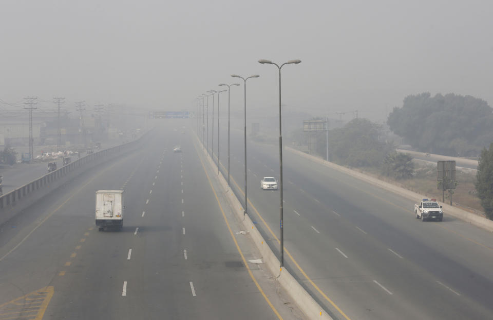 Vehicles drive on a highway as smog envelops the area of Lahore, Pakistan, Wednesday, Nov. 11, 2020. People in Pakistan’s cultural capital of Lahore were at risk of respiratory diseases and eye-related problems Wednesday after the air quality deteriorated to hazardous levels due to a quilt of smog over the city, prompting doctors to urge people to stay at home. (AP Photo/K.M. Chaudary)