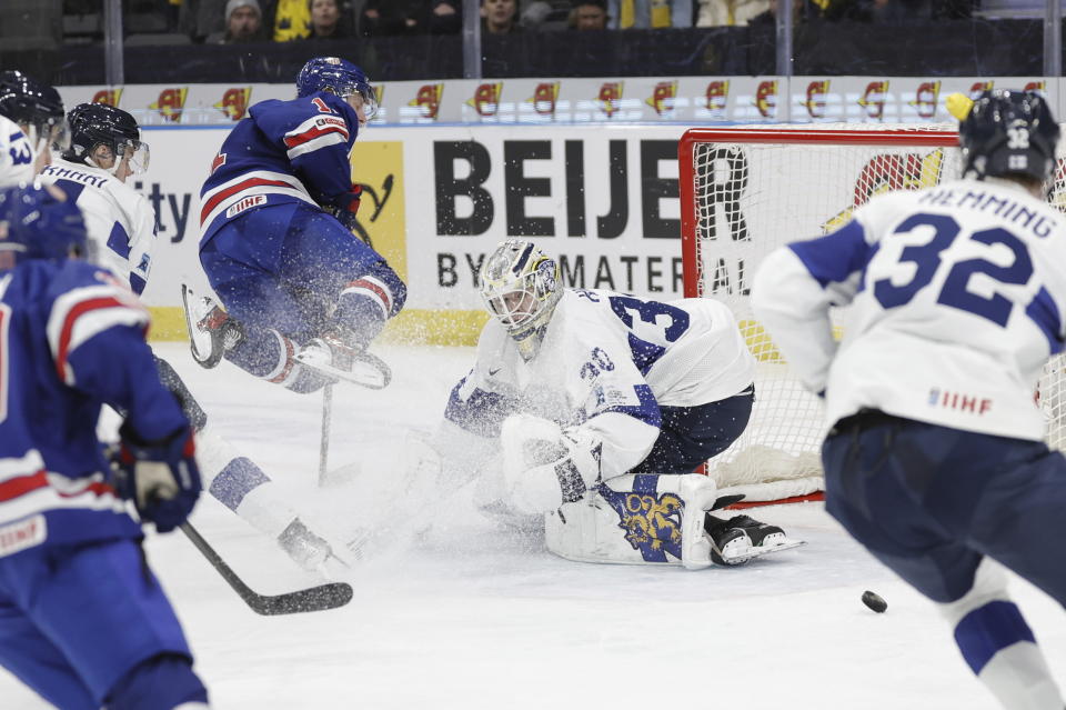 USA's Oliver Moore jumps in front of Finland's Niklas Kokko during the IIHF World Junior Championship ice hockey semifinal match between USA and Finland at Scandinavium in Gothenburg, Sweden, Thursday, Jan. 4, 2024. (Adam Ihse/TT via AP)