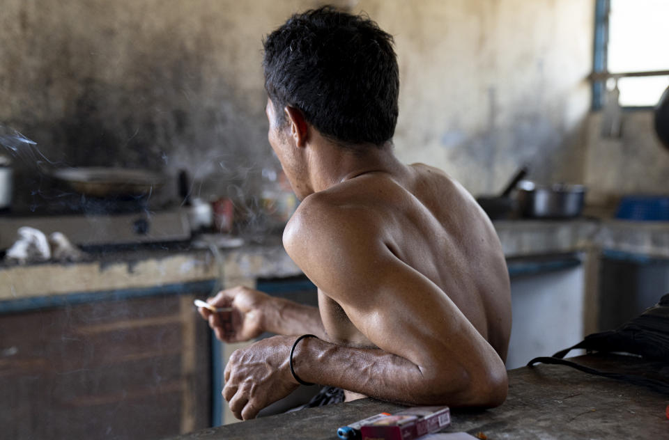 An Indonesian migrant worker rests after working on a palm oil plantation run by the government-owned Felda in Malaysia, in early 2020. Jum, a former worker who escaped from this same plantation, said the company confiscated, and later lost his Indonesian passport, leaving him vulnerable to arrest and forcing him to hide in the jungle. (AP Photo/Ore Huiying)