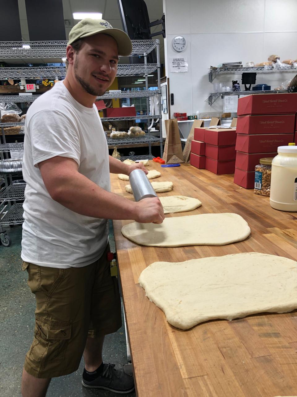 Nick Puski, Great Harvest's head bread baker, rolls out dough for cinnamon rolls at the bakery and café in downtown Ames.