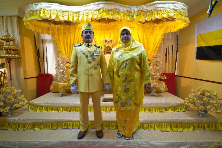 Self-styled royal Raja Noor Jan Shah Raja Tuah Shah and his wife Zaidatul Mardiah Yussuf pose for pictures by a throne before attending a private function at their palace in Gombak, on the outskirt of Kuala Lumpur, on September 7, 2013