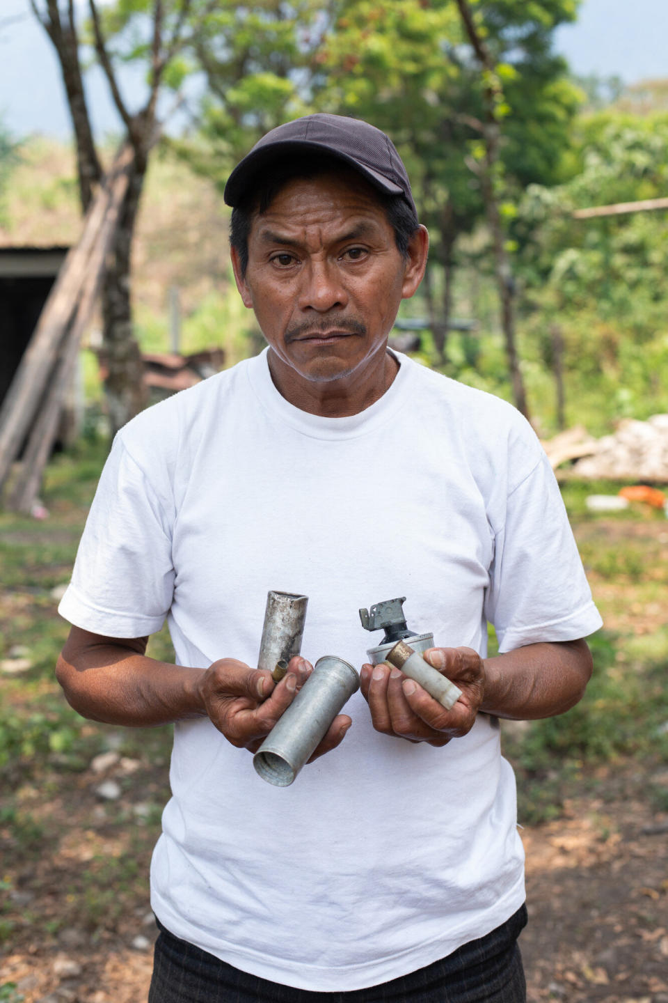 Joel Raymundo Domingo, 55, photographed in April, holds smoke bombs, tear gas canisters and other projectiles used by Guatemalan state forces to disperse a peaceful blockade&nbsp;against the San Mateo Hydroelectric Project, in October 2018.&nbsp; (Photo: Global Witness / James Rodriguez)