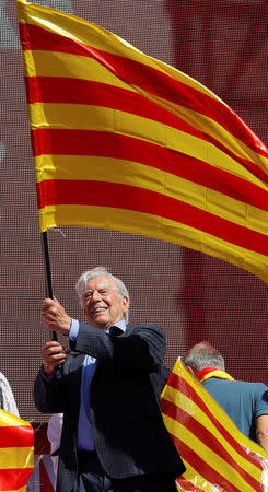 Peruvian Nobel Laureate Mario Vargas Llosa waves a Catalan flag during a pro-union demonstration organised by the Catalan Civil Society organisation in Barcelona, Spain, October 8, 2017. REUTERS/Eric Gaillard