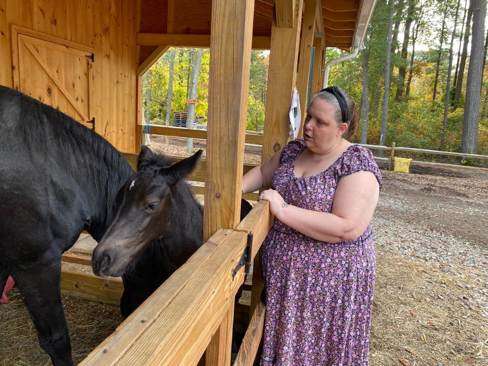 Angel Burge of Fall River visits her favorite horse, Midnight, along with Midnight's baby, Zara, at Deep Pond Farm & Stables in Taunton on Friday, Oct. 6, 2023. Burge describes these trips as therapeutic for her as she deals with health challenges.