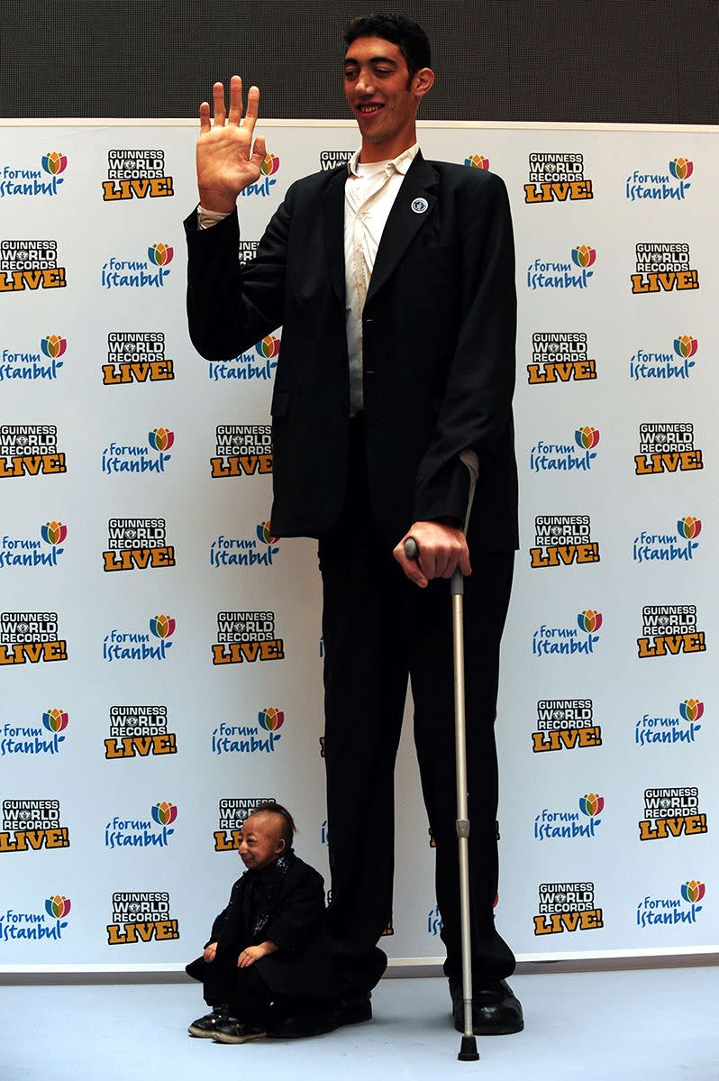 Here posing with the smallest man in the world, Sultan Kosen says he is now proud of his height. Photo: Getty.