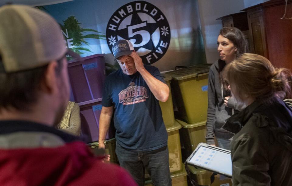 A cannabis farmer talks with state inspectors.