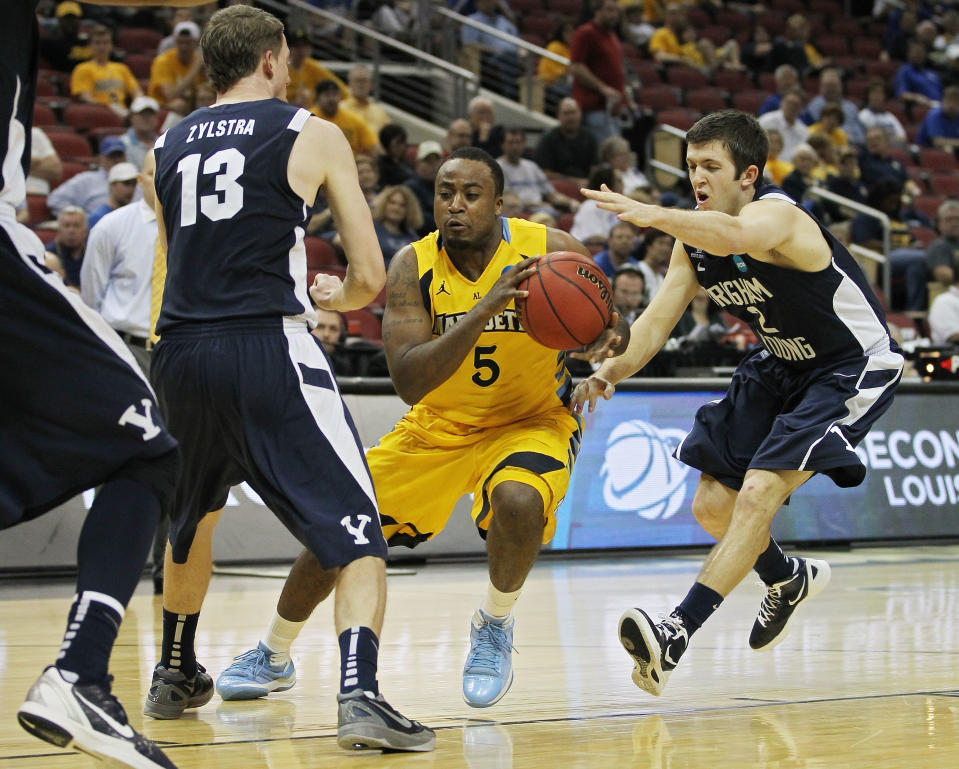 LOUISVILLE, KY - MARCH 15: Junior Cadougan #5 of the Marquette Golden Eagles handles the ball against Brock Zylstra #13 and Craig Cusick #2 of the Brigham Young Cougars during the second round of the 2012 NCAA Men's Basketball Tournament at KFC YUM! Center on March 15, 2012 in Louisville, Kentucky. (Photo by Jonathan Daniel/Getty Images)