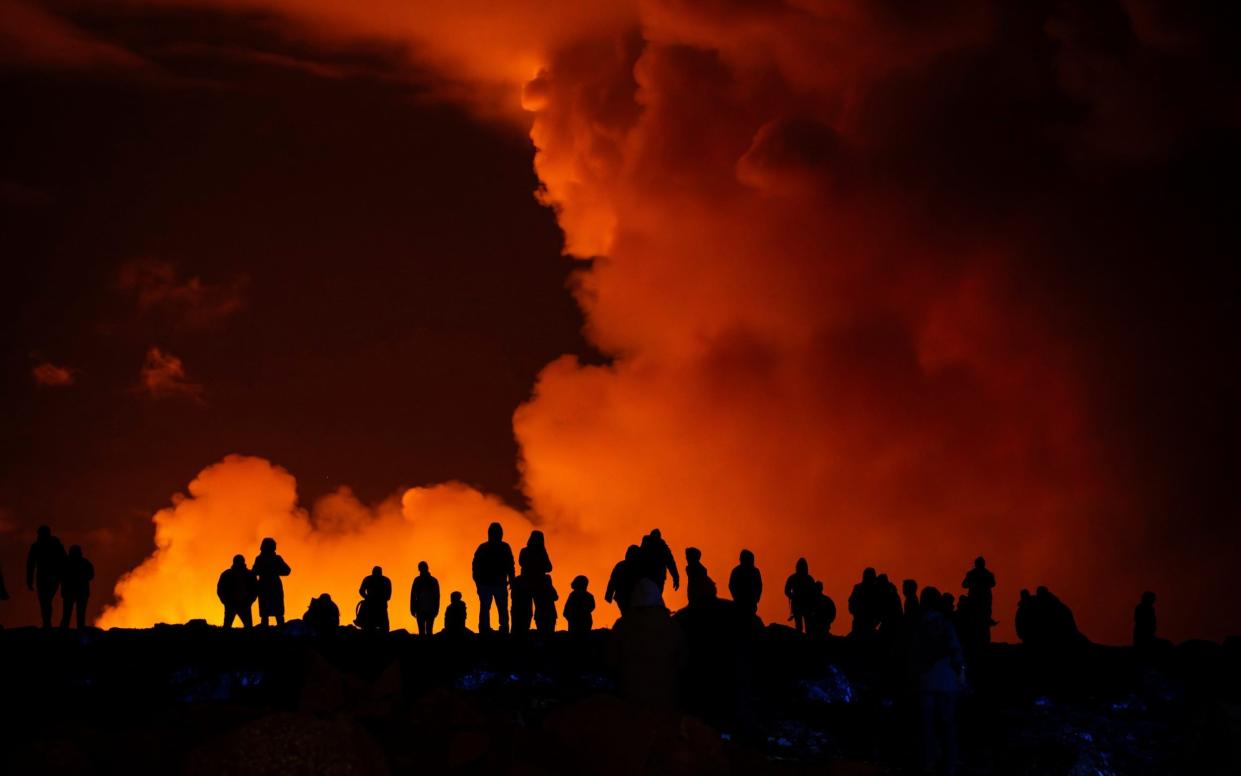 Spectators watch plumes from Saturday's volcanic activity