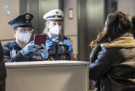 FILE - In this Sunday, Jan. 24, 2021 file photo, officers of the German Federal Police check passengers arriving by plane from Prague at the Frankfurt Airport in Frankfurt, Germany. The European Union's executive body proposed Monday Jan. 25, 2021, that the bloc's 27 nations impose more travel restrictions to counter the worrying spread of new coronavirus variants but make sure to keep goods and workers moving across EU borders. (Boris Roessler/dpa via AP, File)