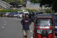 Motorists wait in a queue expecting to buy fuel in Colombo, Sri Lanka, Sunday, June 26, 2022. Sri Lankans have endured months of shortages of food, fuel and other necessities due to the country's dwindling foreign exchange reserves and mounting debt, worsened by the pandemic and other longer term troubles. (AP Photo/Eranga Jayawardena)