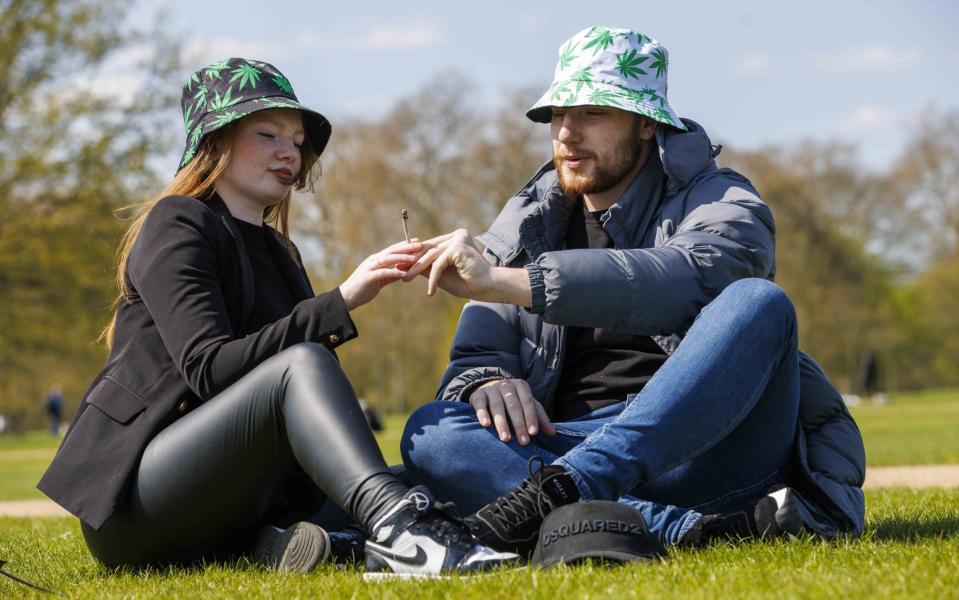 A man and woman smoke on the grass in Hyde Park on Thursday - Mark Thomas/Shutterstock