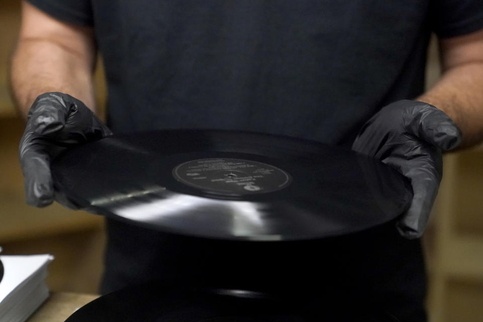 Ricky Riehl inspects finished vinyl records for physical flaws before they are packaged at the United Record Pressing facility Thursday, June 23, 2022, in Nashville, Tenn. (AP Photo/Mark Humphrey)