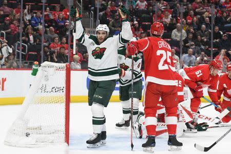 Feb 22, 2019; Detroit, MI, USA; Minnesota Wild center Luke Kunin (19) celebrates after scoring a goal past Detroit Red Wings goaltender Jonathan Bernier (45) during the first period at Little Caesars Arena. Mandatory Credit: Tim Fuller-USA TODAY Sports