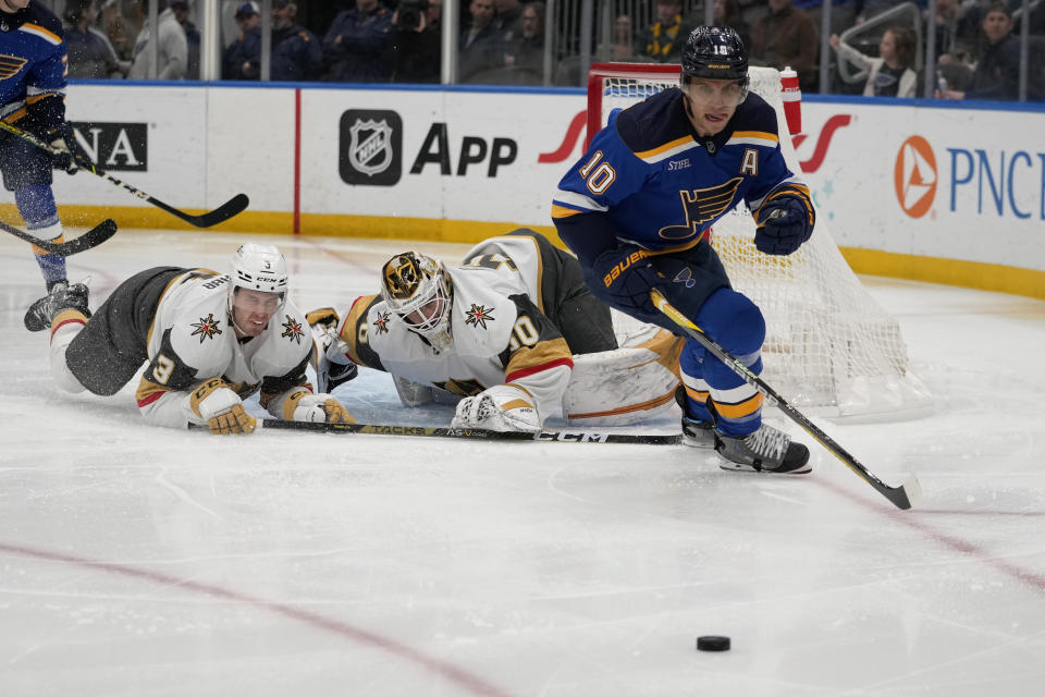 St. Louis Blues' Brayden Schenn (10) chases after a loose puck as Vegas Golden Knights goaltender Jiri Patera and Brayden McNabb watch during the second period of an NHL hockey game Sunday, March 12, 2023, in St. Louis. (AP Photo/Jeff Roberson)