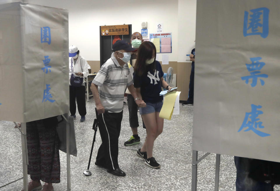 Members of the Nationalist Party, or KMT, prepare to cast their ballot for election of its party chairman at a polling station in Taipei, Taiwan, Saturday, Sept. 25, 2021. Fraught relations with neighboring China are dominating Saturday's election for the leader of Taiwan’s main opposition Nationalist Party. (AP Photo/Chiang Ying-ying)