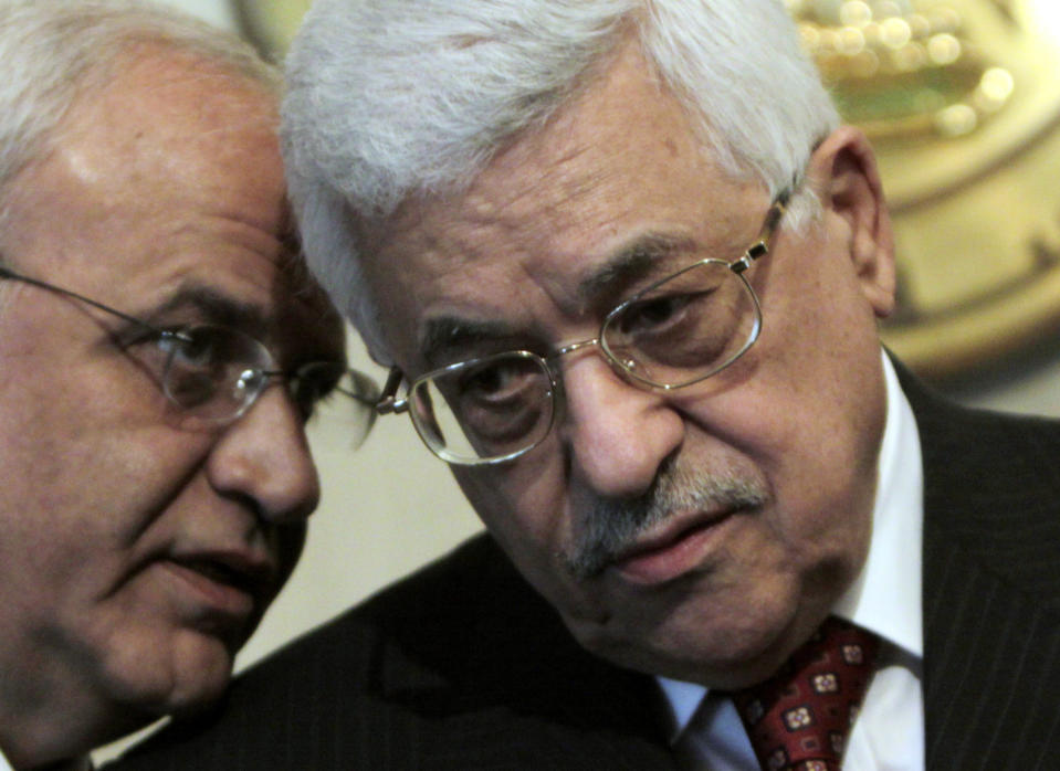 FILE - In this Dec. 28, 2008 file photo, Palestinian President Mahmoud Abbas, right, consults with his aide Saeb Erekat, during a press conference at the Presidential palace in Cairo, Egypt. Erekat, a veteran peace negotiator and prominent international spokesman for the Palestinians for more than three decades, died Tuesday, Nov. 10, 2020. He was 65. (AP Photo/Amr Nabil, File)