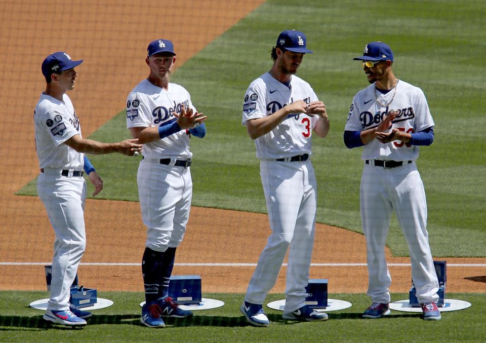 Dodgers players Austin Barnes, left, Matt Beaty, Cody Bellinger and Mookie Betts try on their championship rings.