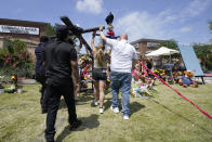 Volunteers prepare to erect a newly constructed cross at a makeshift memorial by the mall where several people were killed, Monday, May 8, 2023, in Allen, Texas. (AP Photo/Tony Gutierrez)