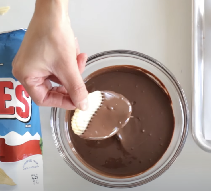 dipping wavy chip into melted chocolate