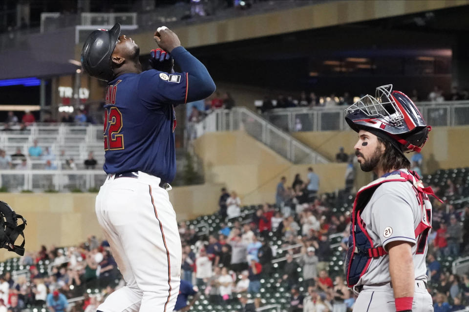 Minnesota Twins' Miguel Sano, left, looks skyward as he scores past Cleveland Indians catcher Austin Hedges on a three-run home run off Indians pitcher Cal Quantrill (47) in the seventh inning of a baseball game, Wednesday, Sept. 15, 2021, in Minneapolis. The Indians won 12-3. (AP Photo/Jim Mone)