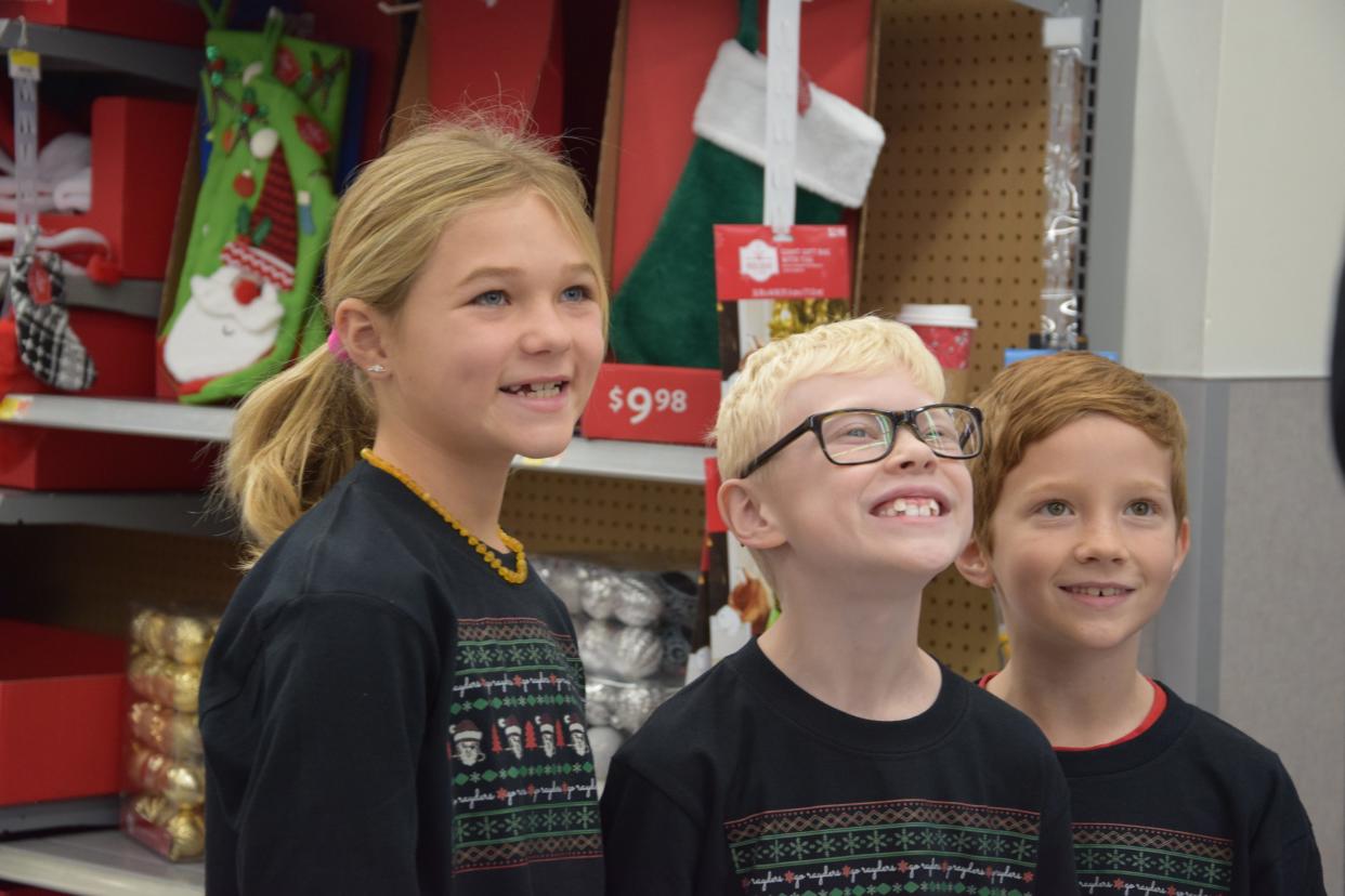Sage Linne, Luke Malewitz and Harvey Thompson pose for a photo after wrapping up their groups' shopping on Monday, Dec. 11, 2023.