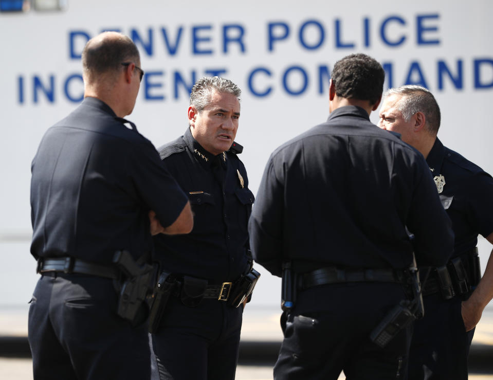 Denver Police Chef Paul Pazen, second from left, talks with other officials near the scene of a triple homicide south of downtown Denver, Thursday, Aug. 9, 2018. Police are trying to determine if the deaths of three homeless people are related to an earlier stabbing in the area. (AP Photo/David Zalubowski)