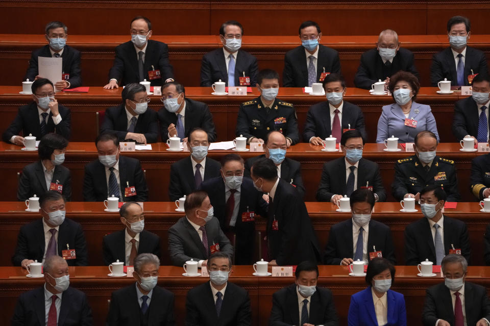 Delegates chat each others as they arrive at the closing ceremony for China's National People's Congress (NPC) at the Great Hall of the People in Beijing, Monday, March 13, 2023. (AP Photo/Andy Wong)