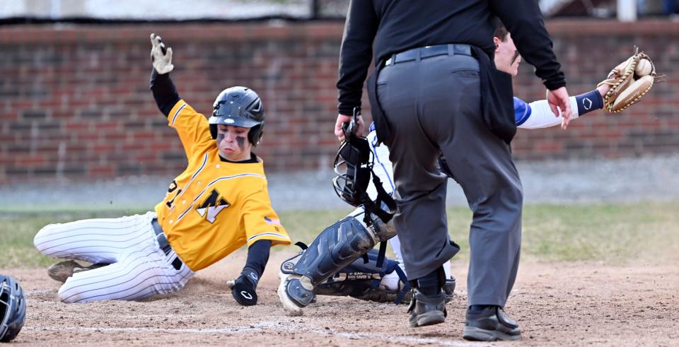 Andrew Dinnan of Nauset slides across home ahead of the tag by St. John Paul II catcher Brady Meyer on Tuesday, April 4, 2023.