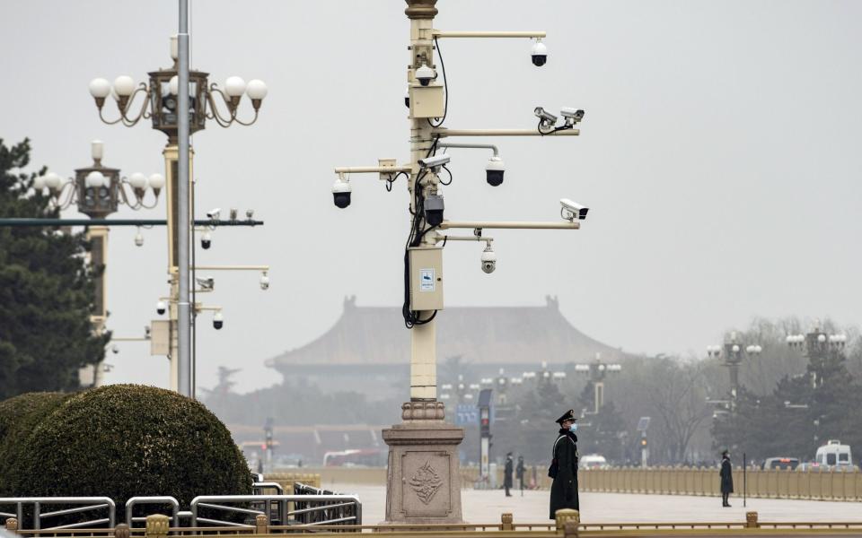 A member of the People's Armed Police wearing a protective mask stands guard under surveillance cameras on the outer perimeter of Tienanmen Square in Beijing, China, on Wednesday, March 3, 2021. - Qilai Shen/Bloomberg