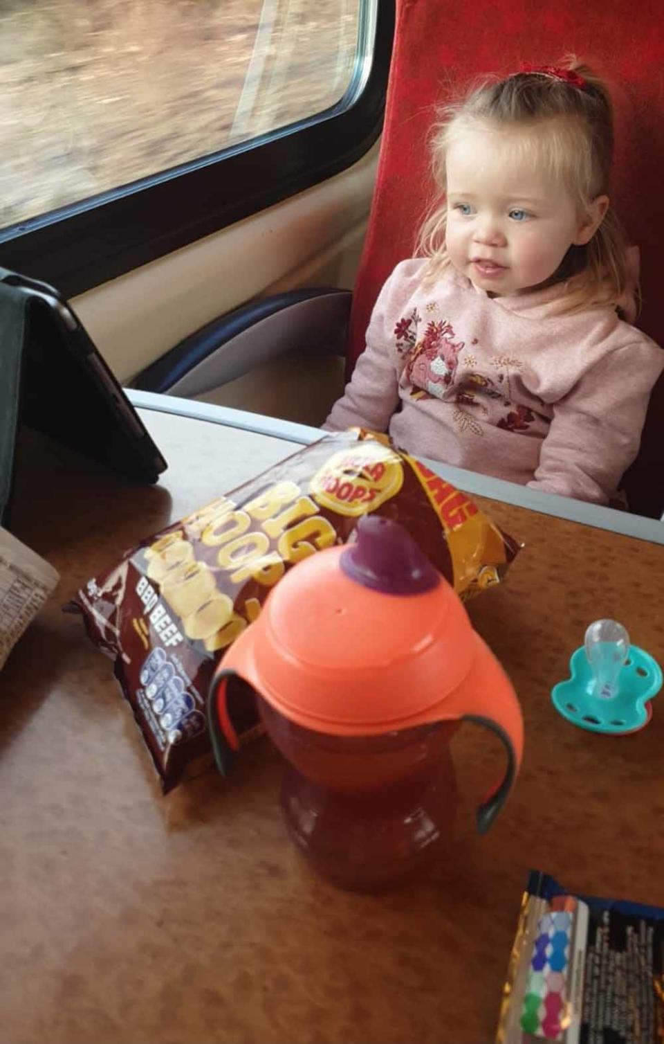 Evie on the train to her first treatment in Birmingham. PA REAL LIFE COLLECT